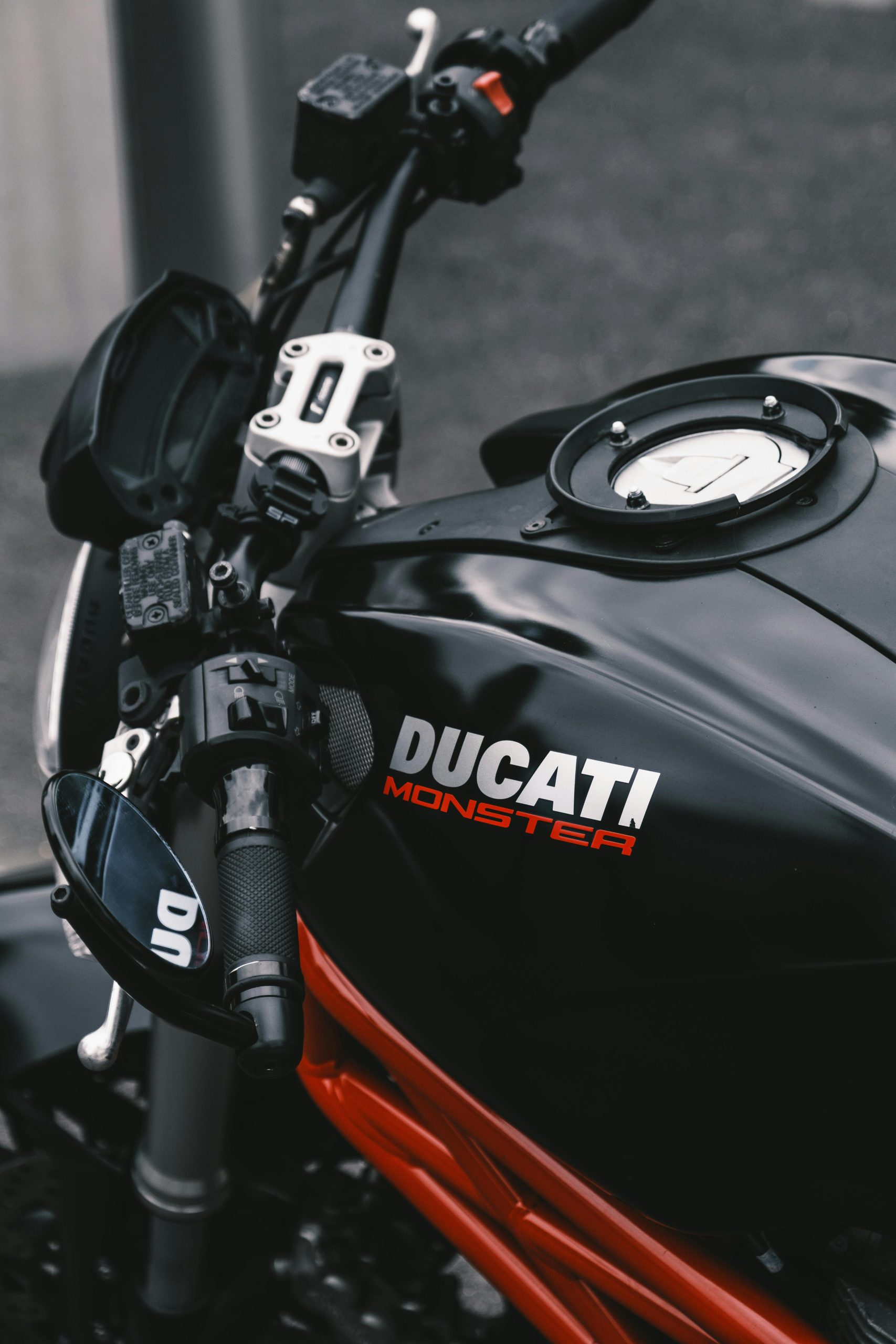 Vue détaillée du réservoir d'une moto Ducati Monster, mettant en valeur un design élégant.