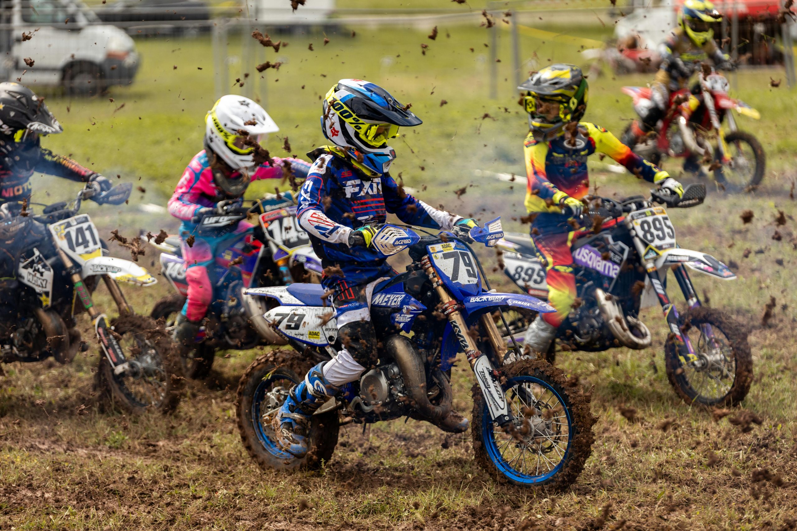 Excitant course de motocross jeunesse sur une piste boueuse mettant en valeur de jeunes pilotes en compétition pleine d'action