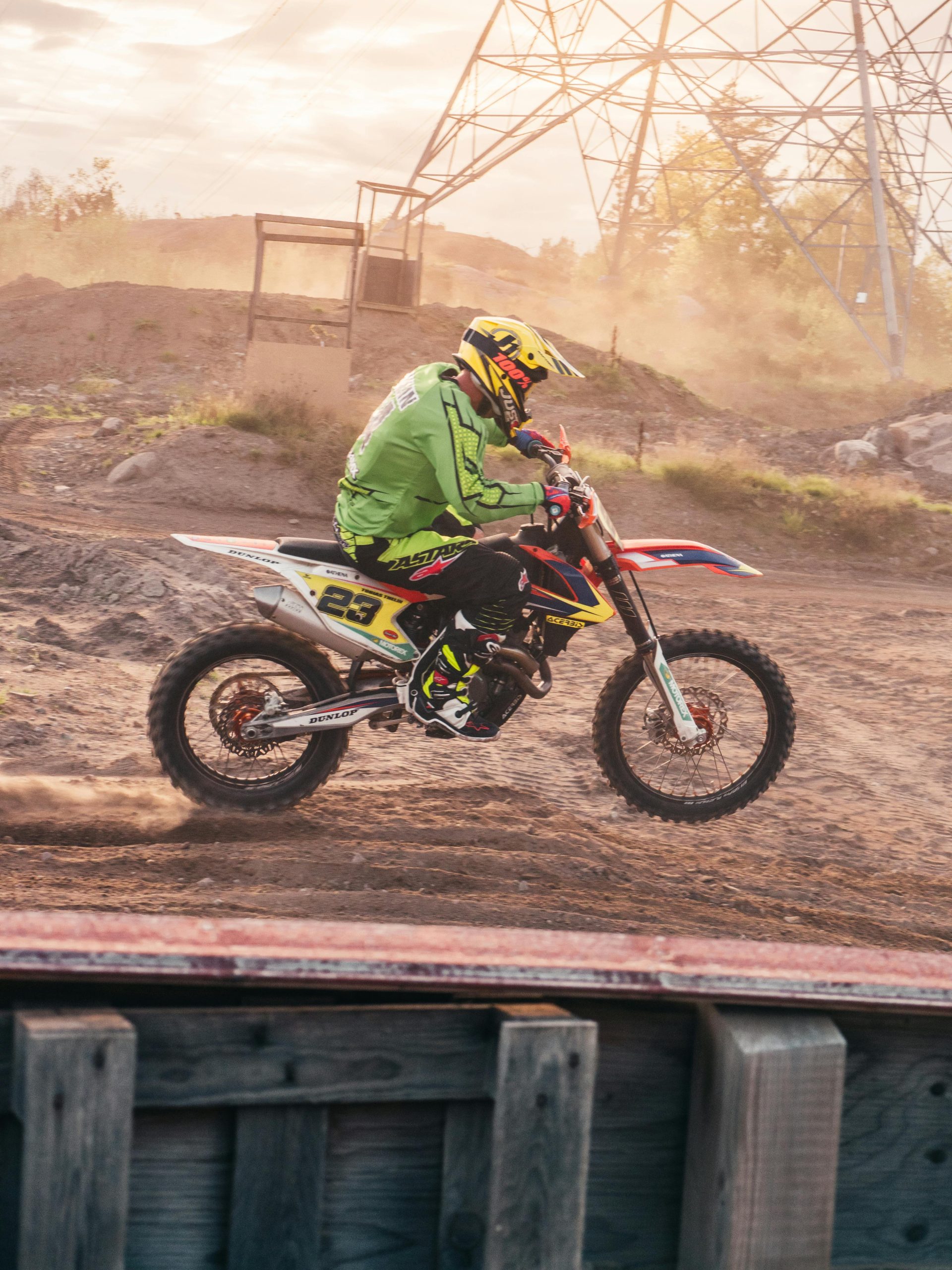 Excitant cliché d'action d'un pilote de motocross filant sur une piste de terre en équipement complet.