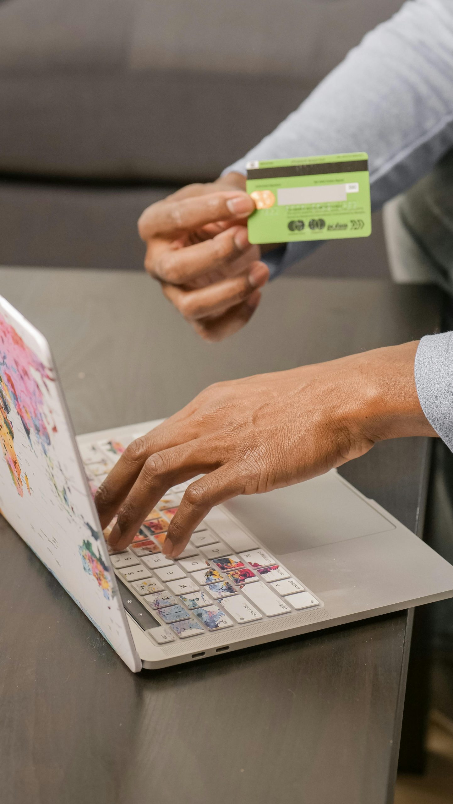 Person using laptop for online shopping with credit card, focusing on digital payment. Personne utilisant un ordinateur portable pour faire des achats en ligne avec une carte de crédit, en se concentrant sur le paiement numérique.