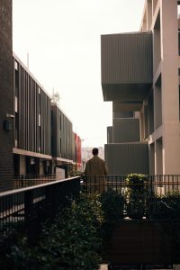 A man stands in an urban street with contemporary buildings in İstanbul, Türkiye. Un homme se tient dans une rue urbaine avec des bâtiments contemporains à İstanbul, Türkiye.