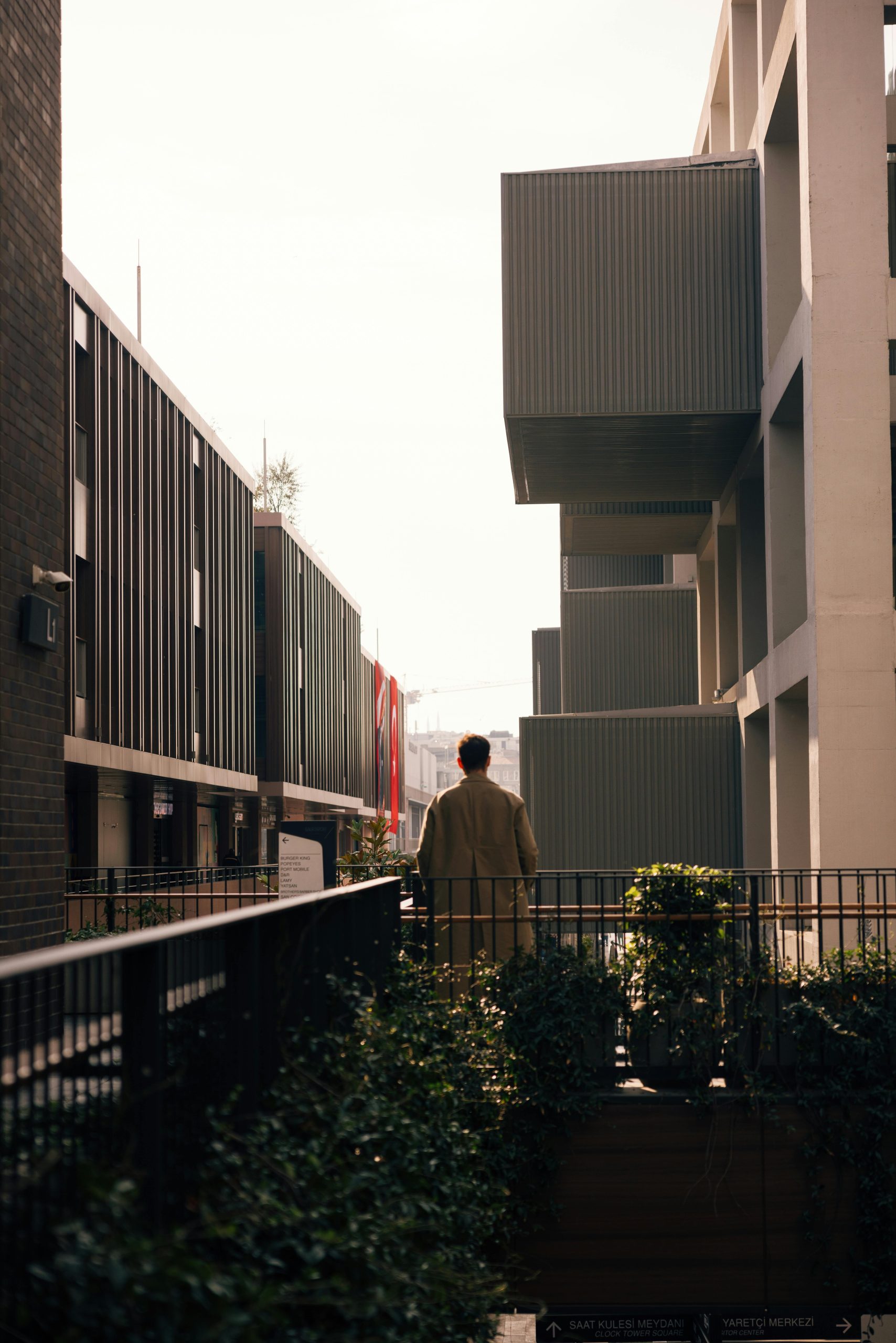 A man stands in an urban street with contemporary buildings in İstanbul, Türkiye. Un homme se tient dans une rue urbaine avec des bâtiments contemporains à İstanbul, Türkiye.