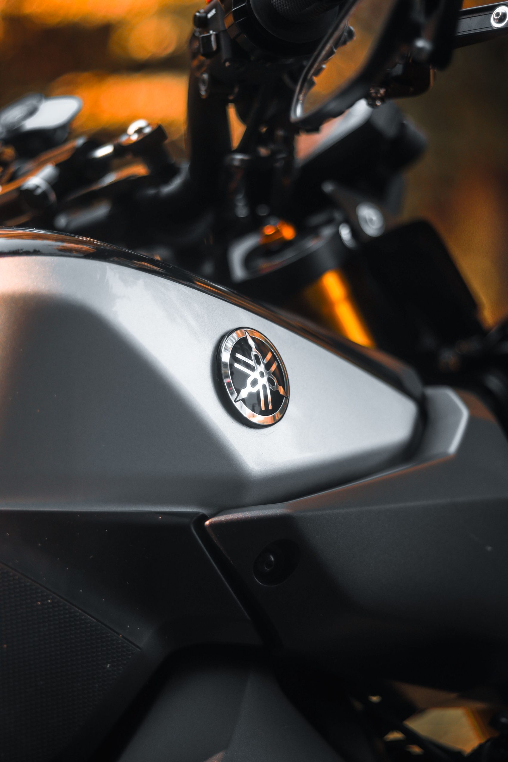 Close-up shot of a matte Yamaha motorcycle showcasing sleek design and branding. Gros plan d'une moto Yamaha mate mettant en avant un design épuré et l'image de marque.