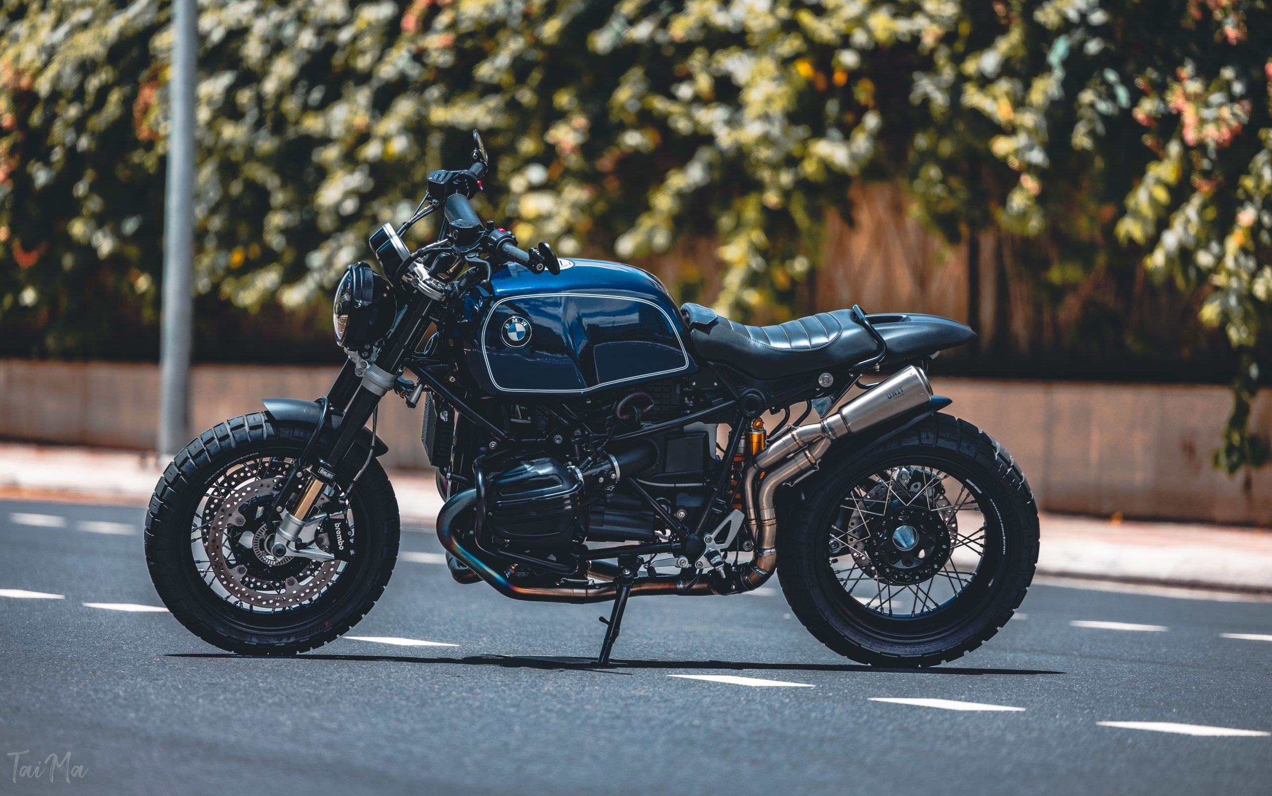 Élégante moto noire garée dans une rue urbaine sous la lumière du soleil, mettant en avant son design moderne.