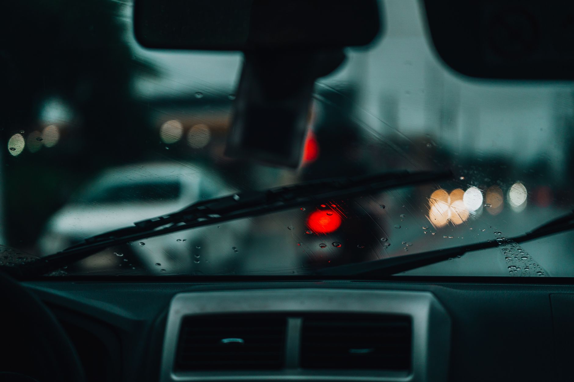 Pluie sur un pare-brise de voiture la nuit en ville
