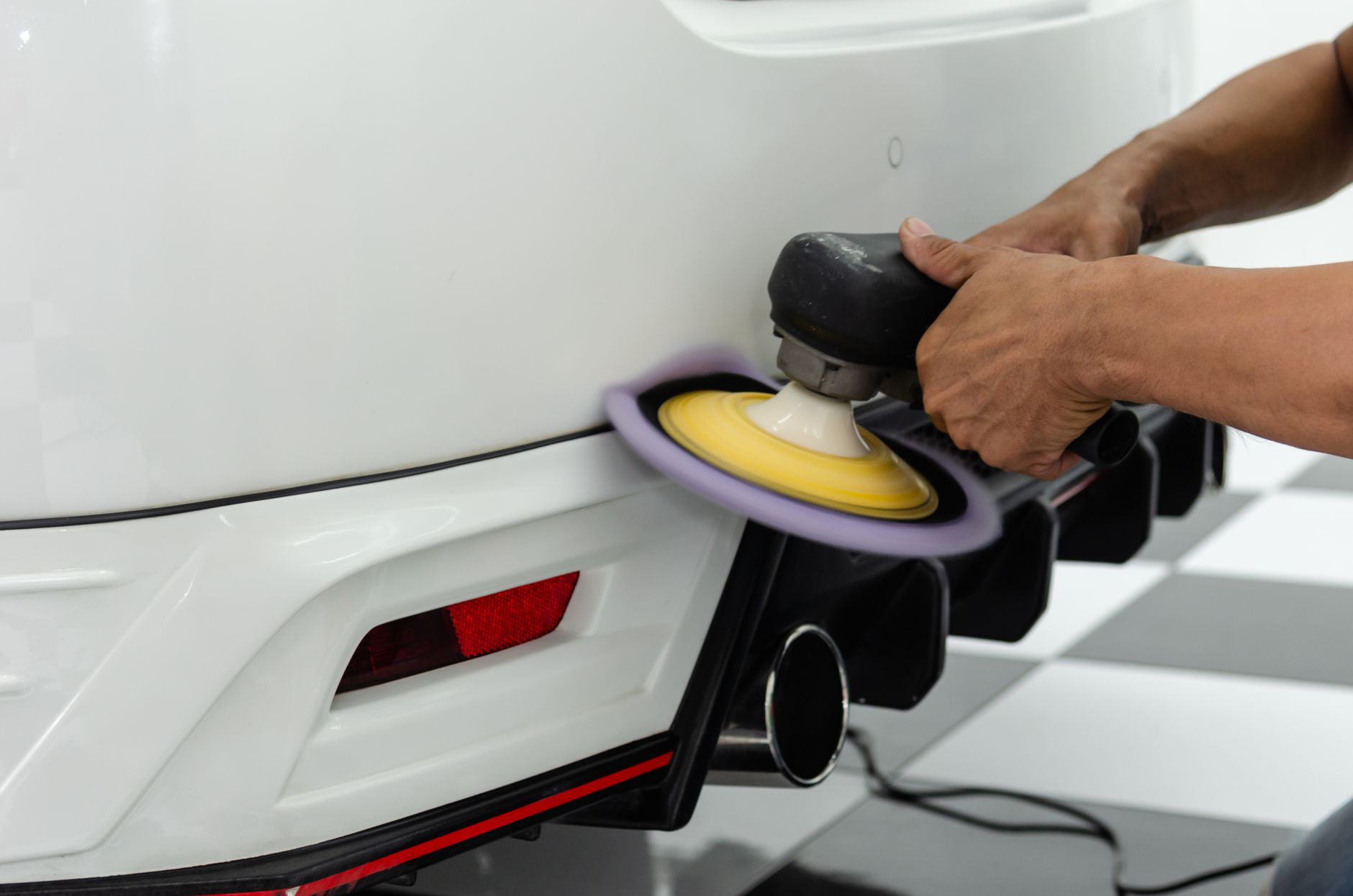 Retouche de peinture sur un pare-chocs de voiture