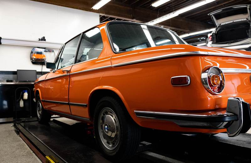 Voiture ancienne orange garée dans un atelier automobile