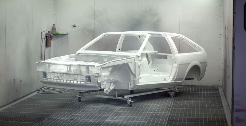 Châssis de voiture en cours de peinture en cabine