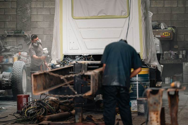 Techniciens qui peignent un châssis de voiture