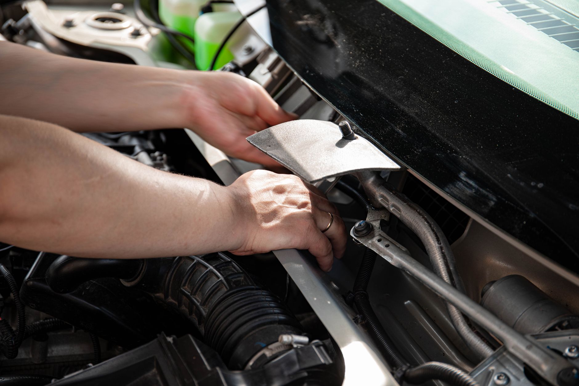 Mains d'un mécanicien qui répare un moteur de voiture