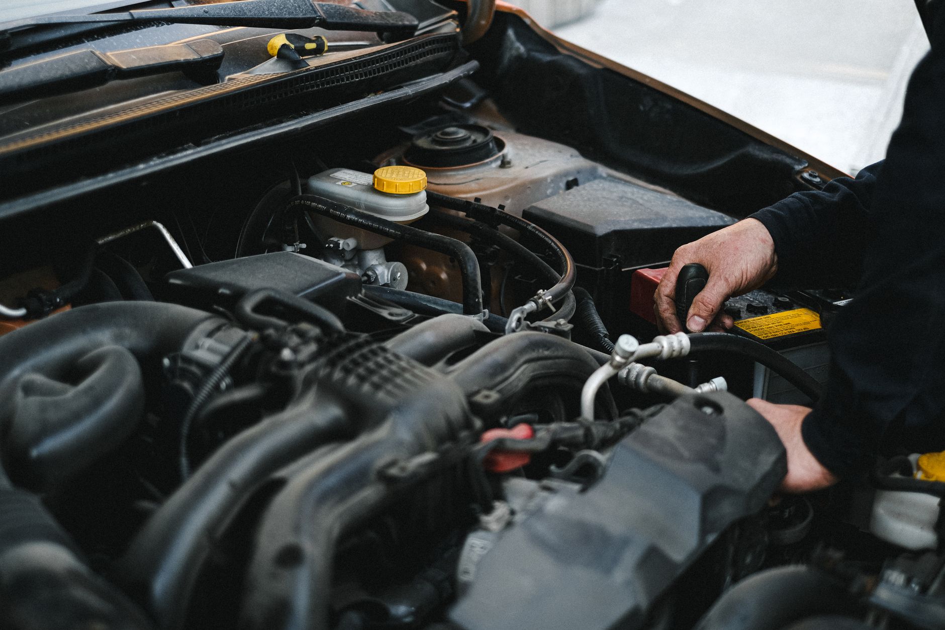 Mains d'un mécanicien au travail sur un moteur de voiture