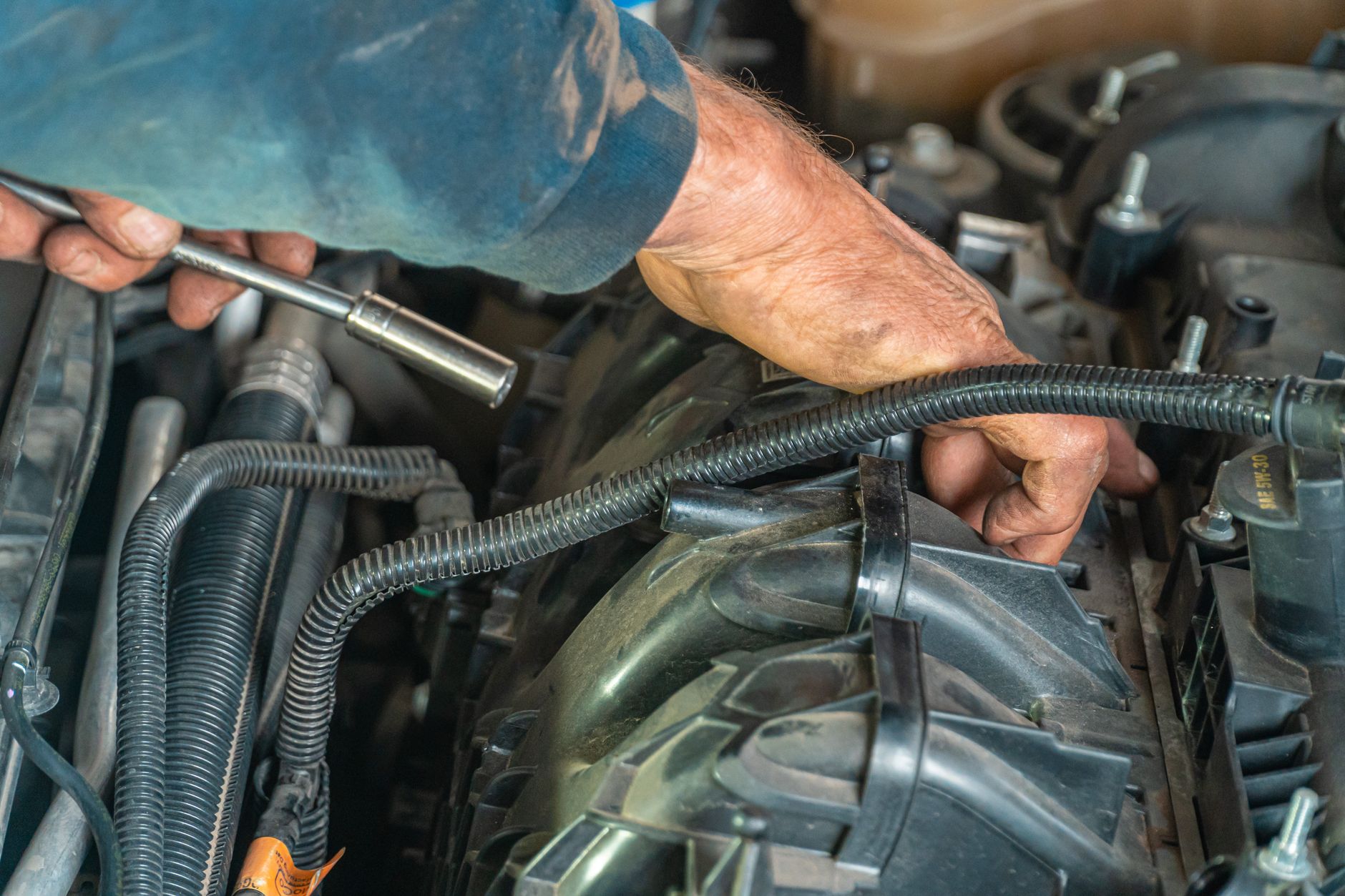 Mécanicien qui contrôle le moteur d'une voiture lors d'une révision