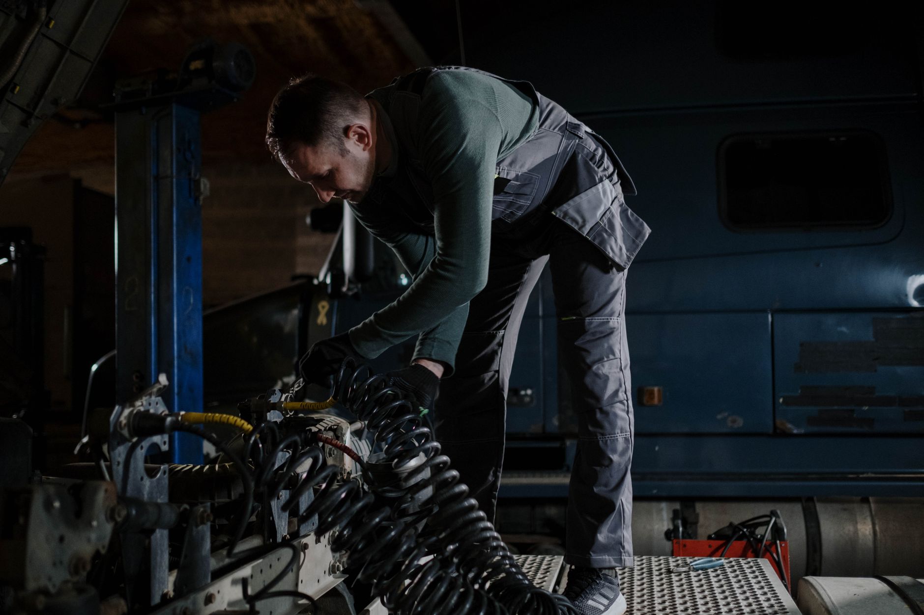 Mécanicien qui contrôle des composants moteur dans un garage