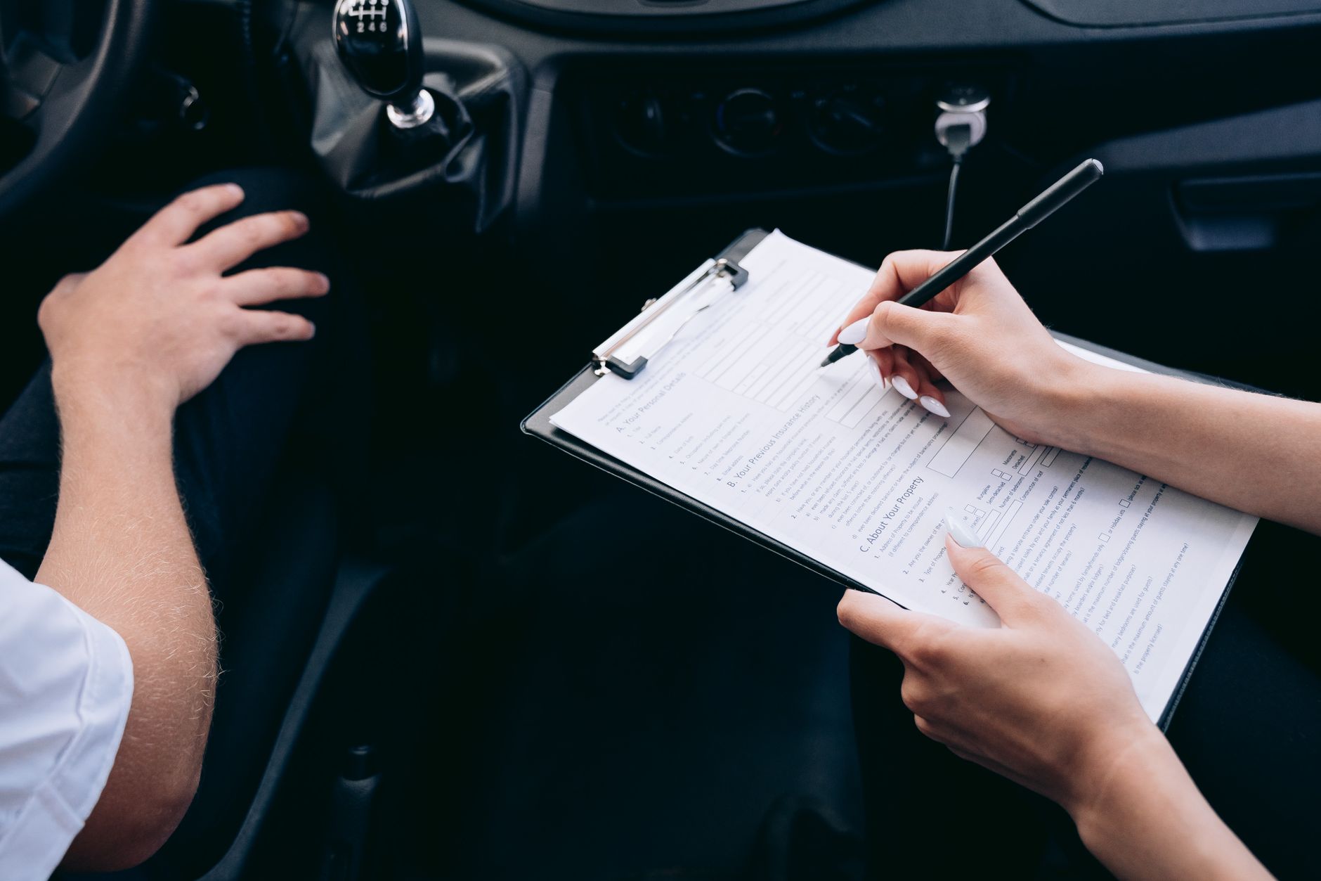 Main qui remplit un contrat d'assurance auto