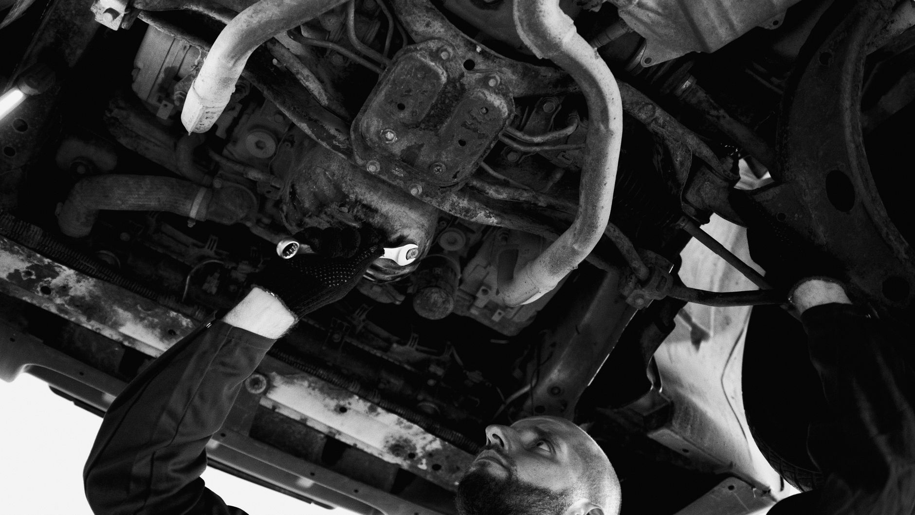 Mécanicien examinant le dessous d’une voiture en atelier