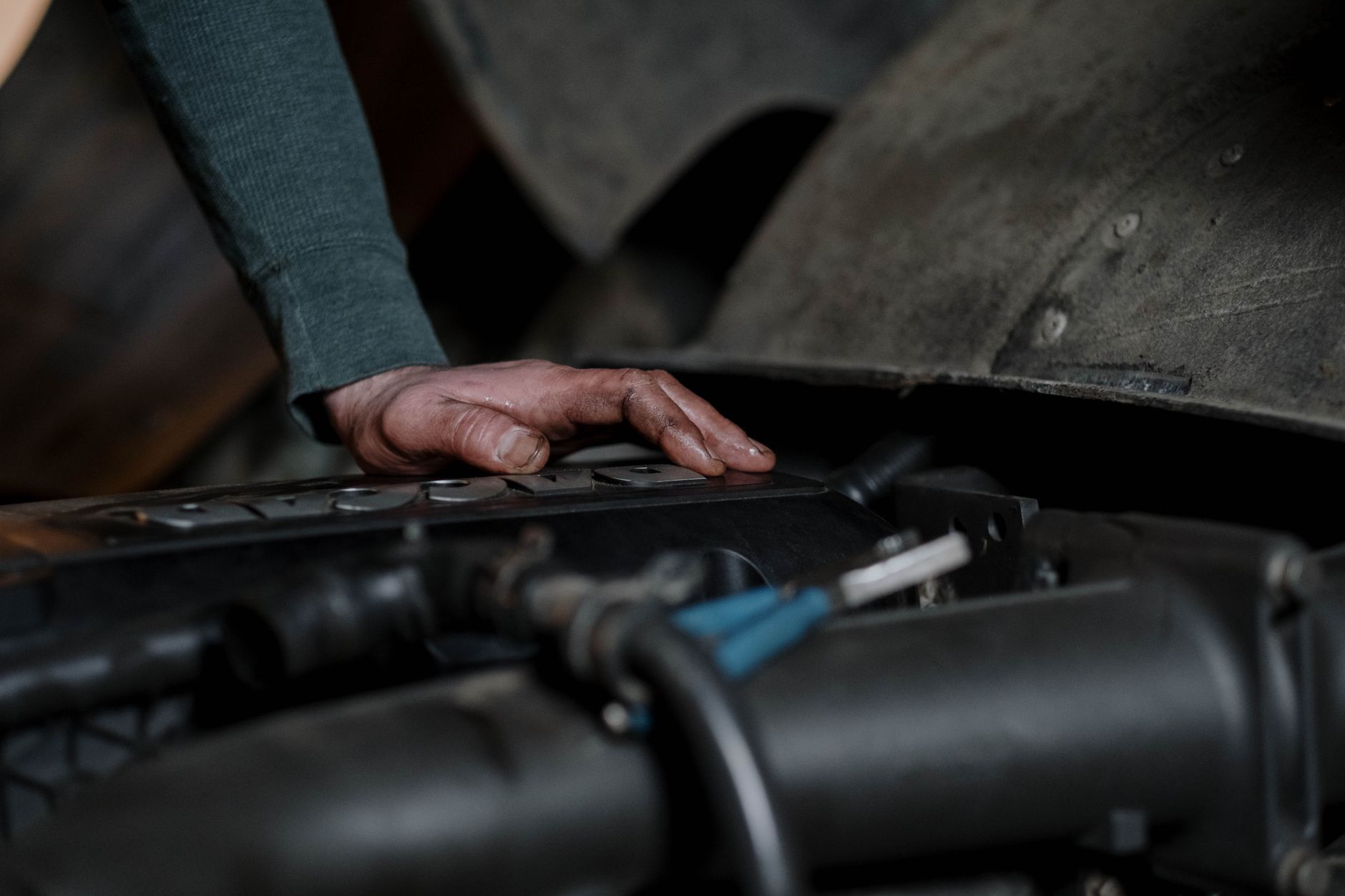 Technicien aux mains sales examinant un véhicule