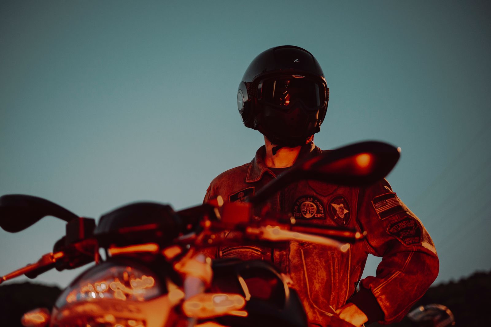 Motard au casque appuyé sur sa moto sportive