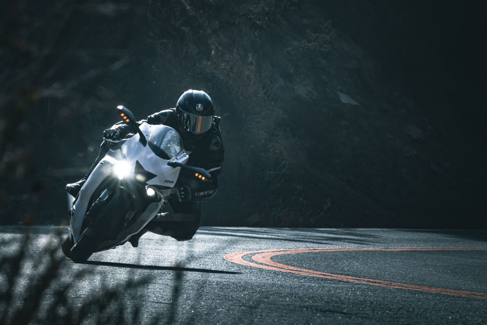 Moto sportive inclinée dans un virage sur route sinueuse