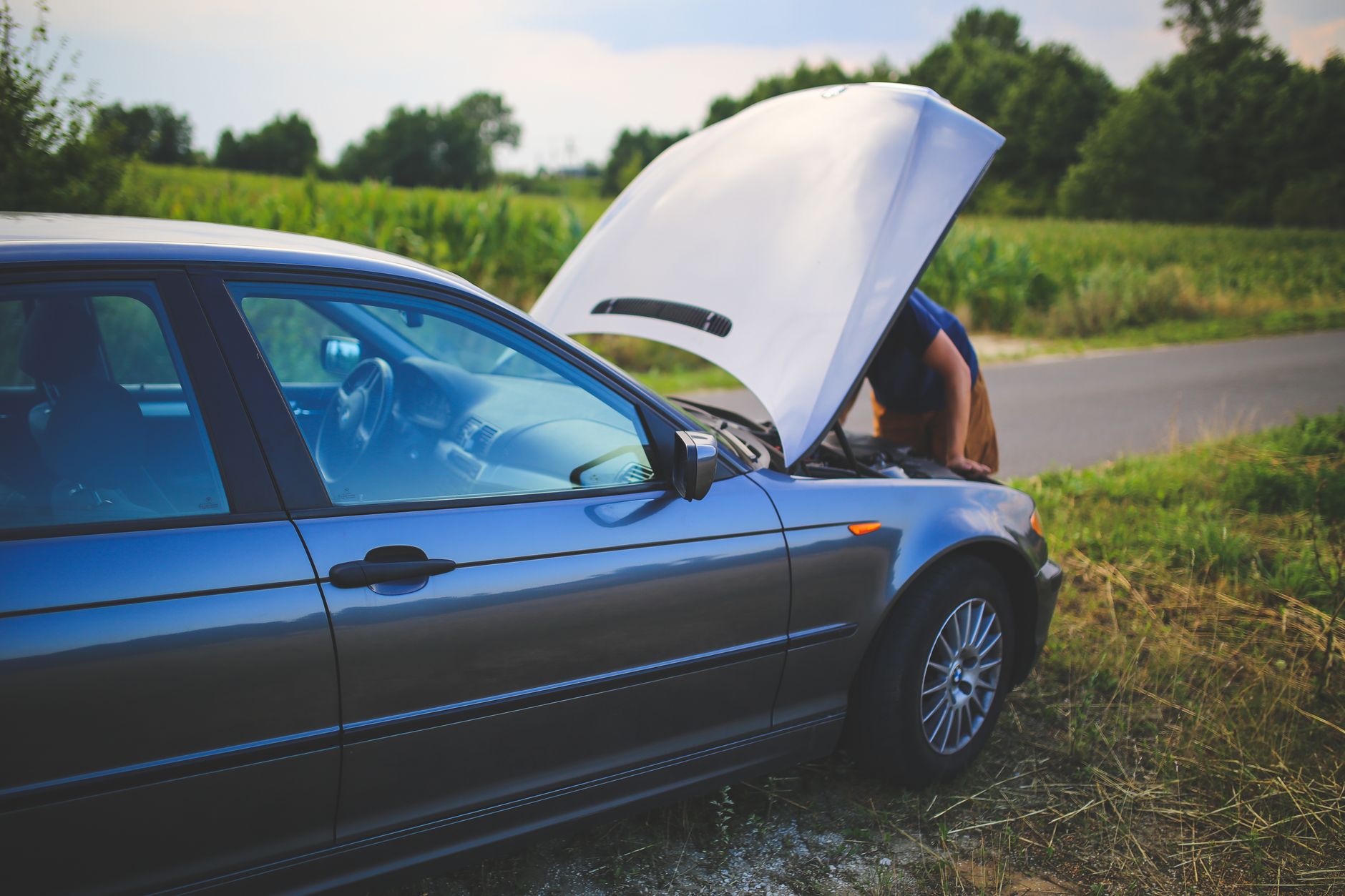 Conducteur devant le capot ouvert au bord de la route