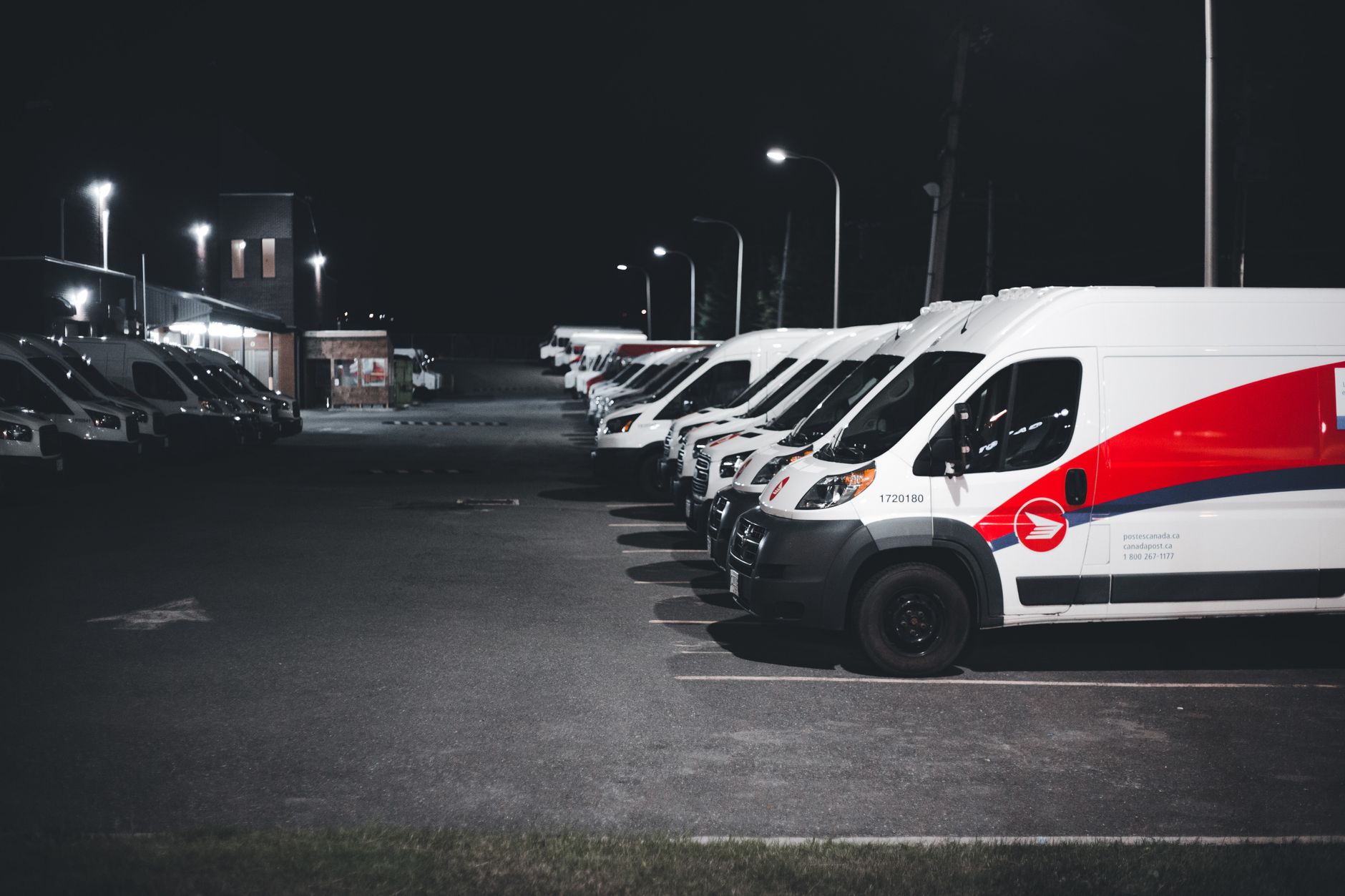 Flotte d’utilitaires blancs et rouges sur un parking